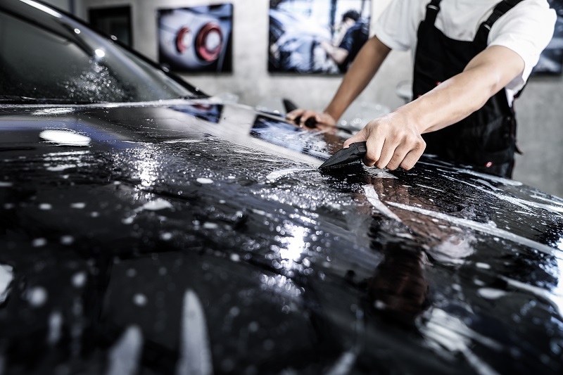 worker applying nano coating on a car